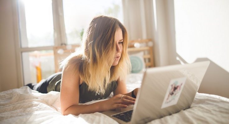 woman on bed with computer doing affiliate marketing business