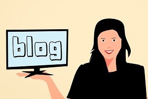woman holding a screen with the word blog on it